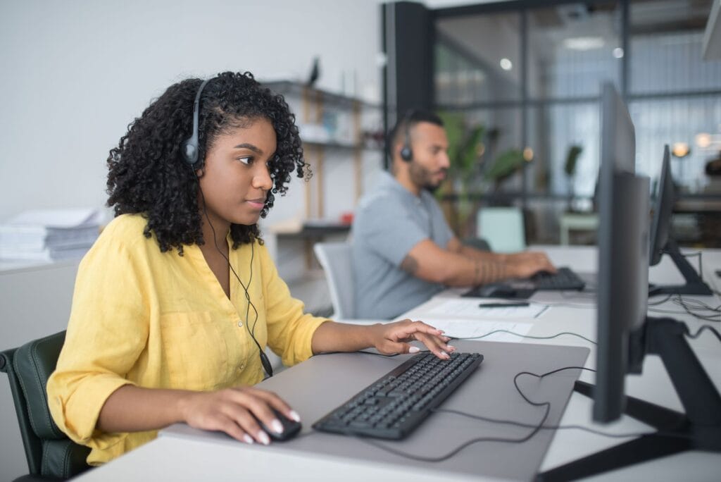 Call center agents with headsets working at computers to qualify and transfer mortgage leads
