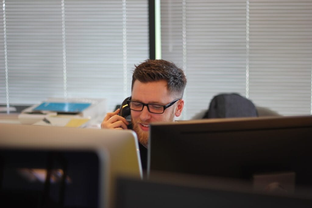 Sales professional on the phone at an office desk working mortgage leads