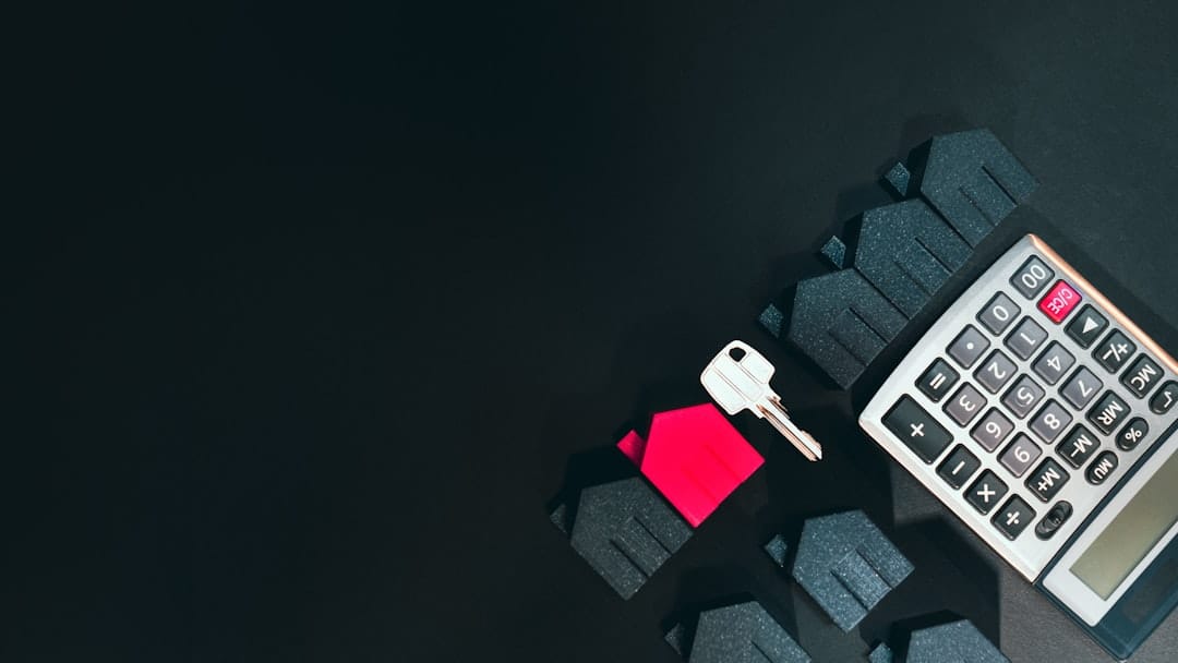 House key and calculator on dark background representing mortgage loan decisions and trigger lead data